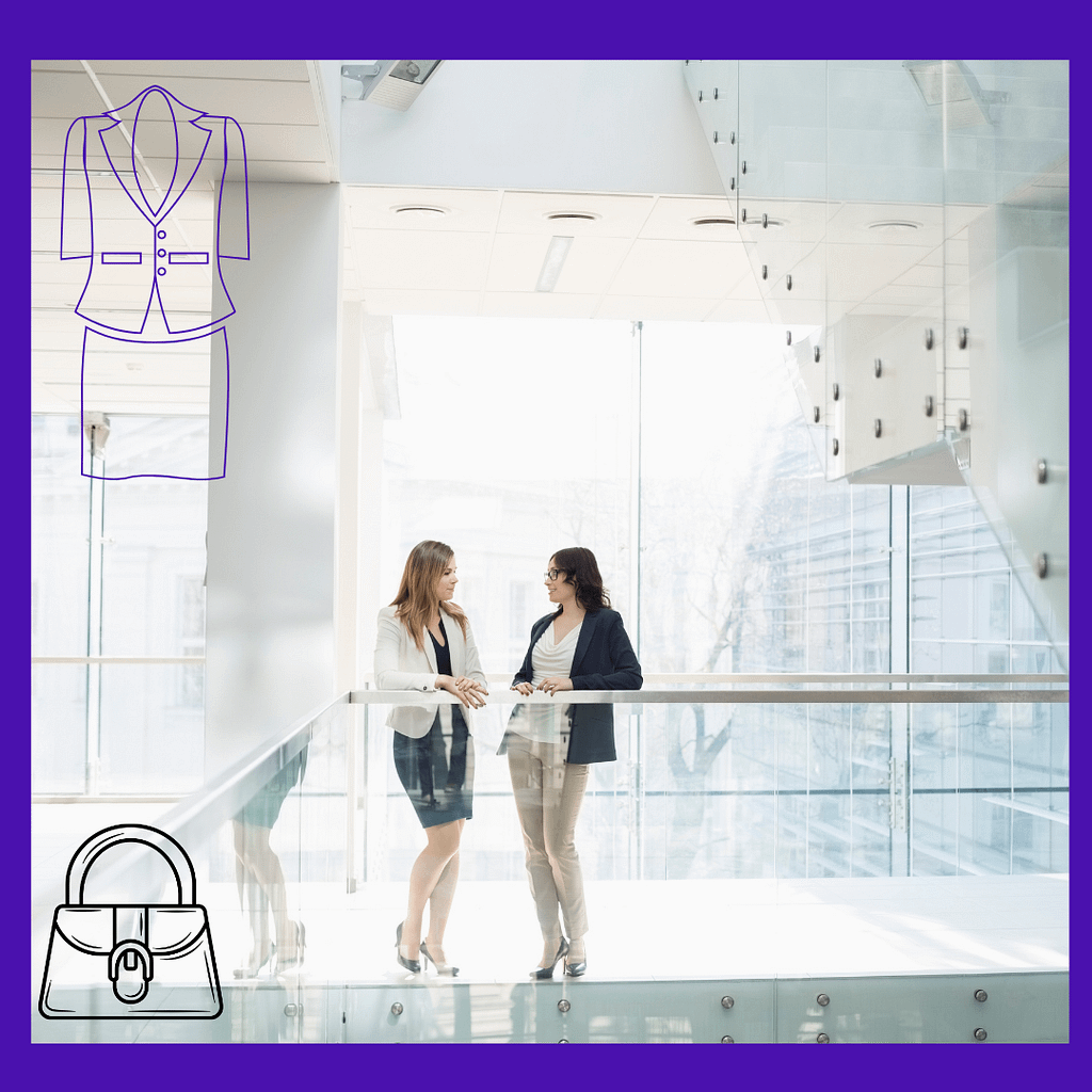 Two women in business suits are talking to each other in an office.