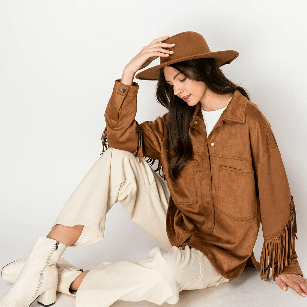 A woman dressed in country style wearing a hat is sitting on the floor.