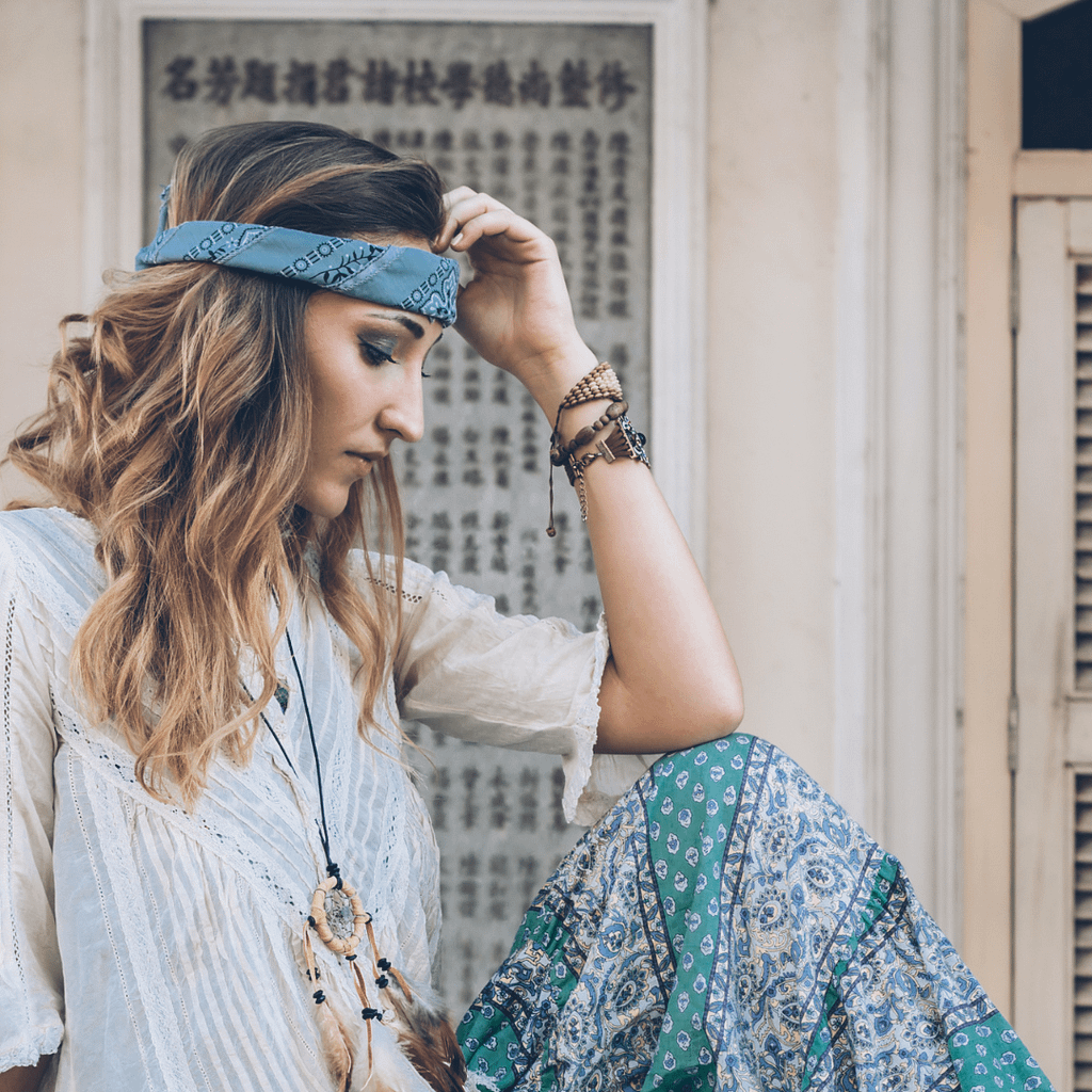 A woman in boho-style clothing sitting in profile