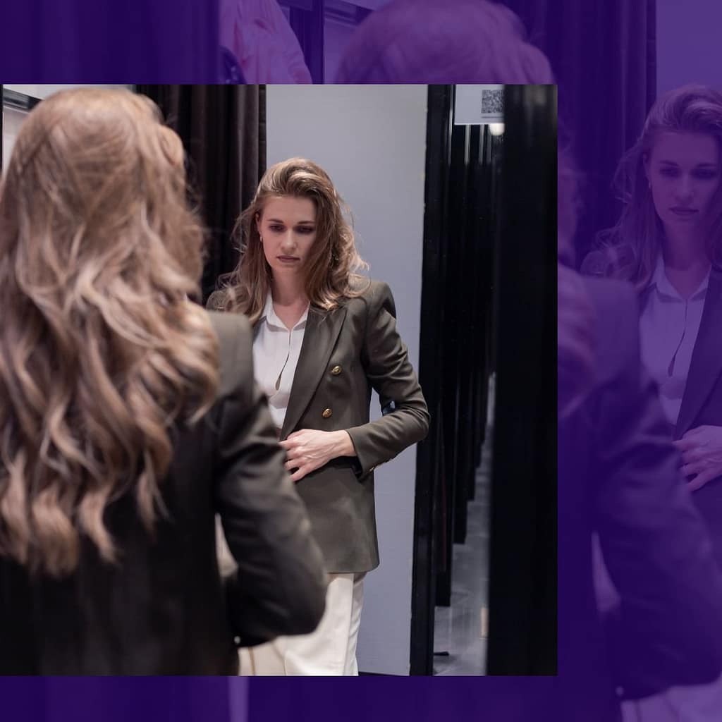 Woman looking at her reflection in a fitting room mirror, body image concept